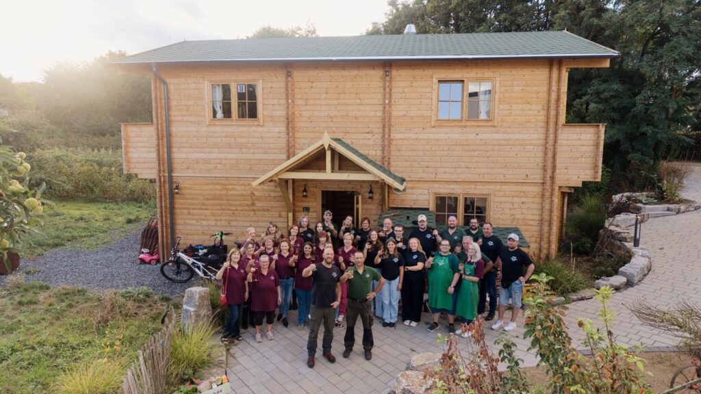 Das Team der Almhütte mit den Brüdern Hoss vorne stößt vor der Almhütte auf dem Lindenhof in Kriftel an